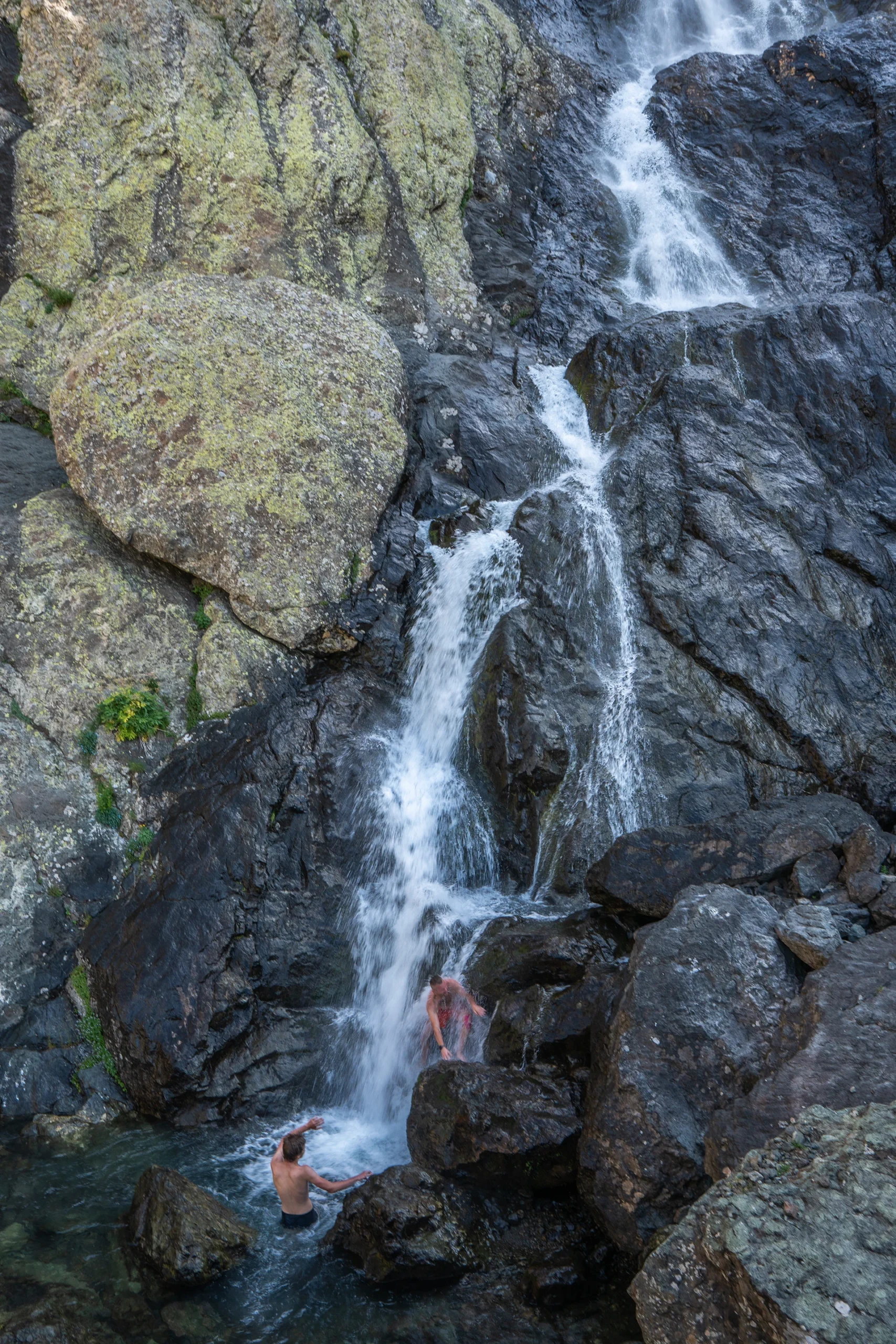 Waterval stroomt tussen met mos bedekte rotsen