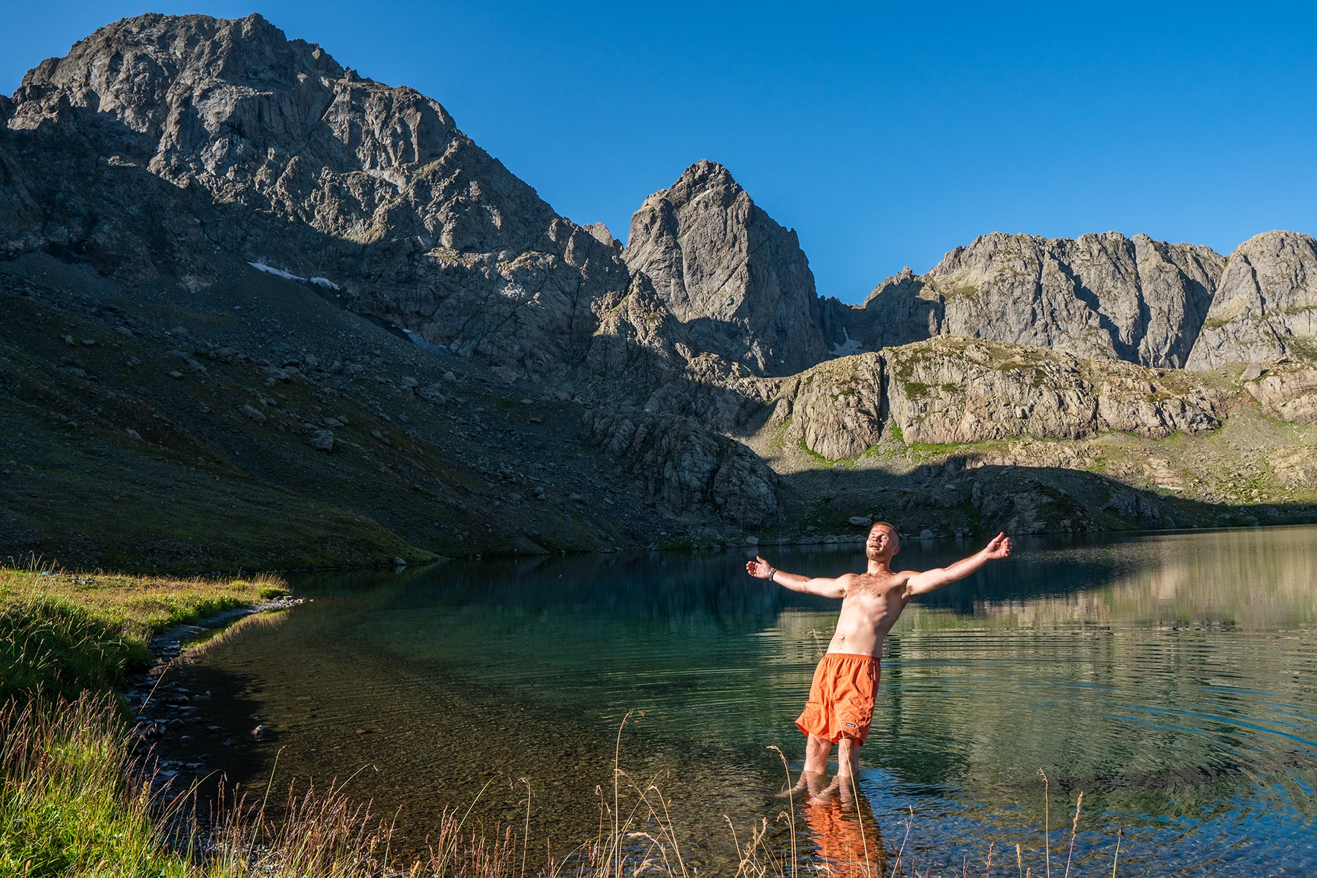 Man staat in bergmeer met steile wanden