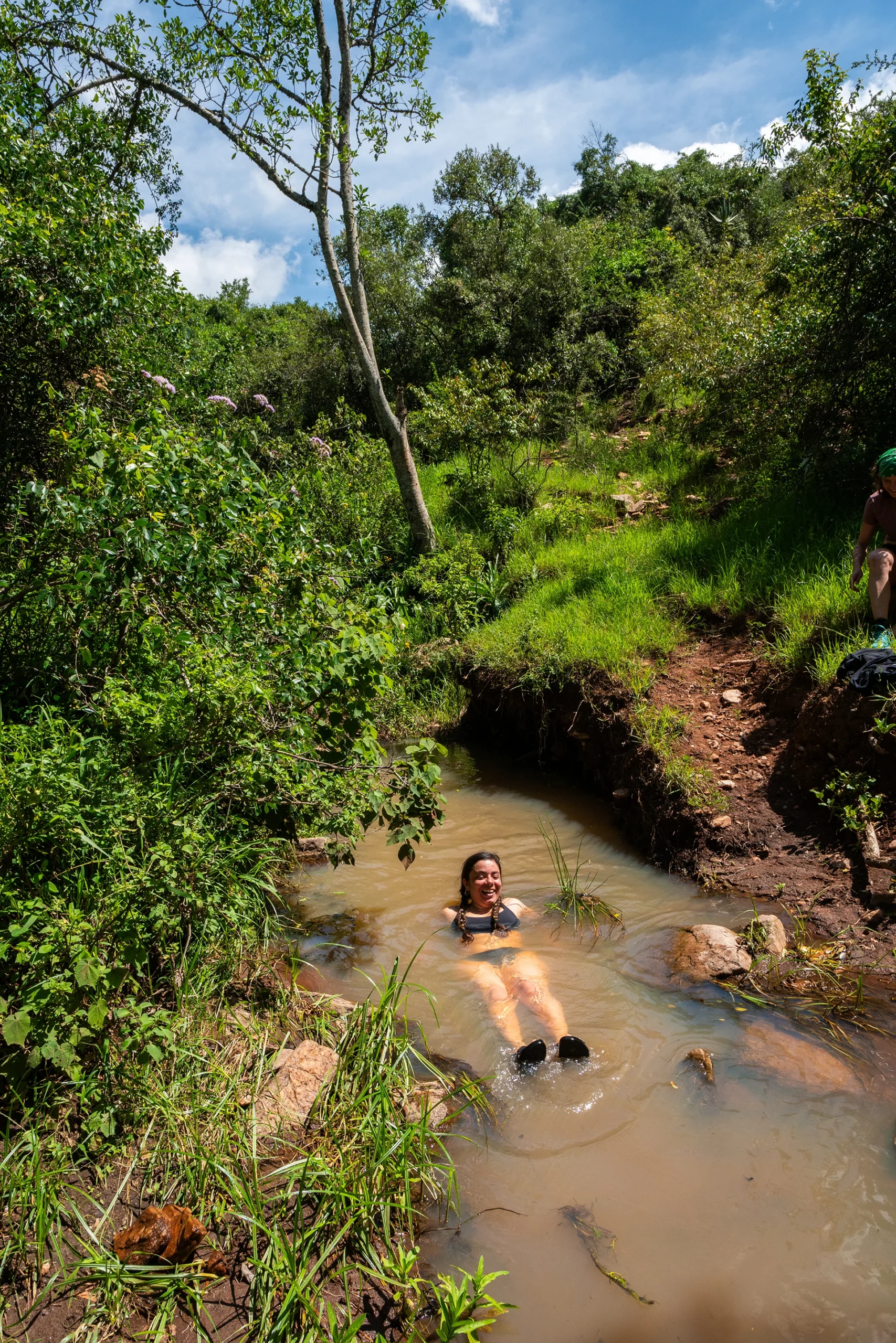 Vrouw rust in rivierpoeltje omringd door jungle