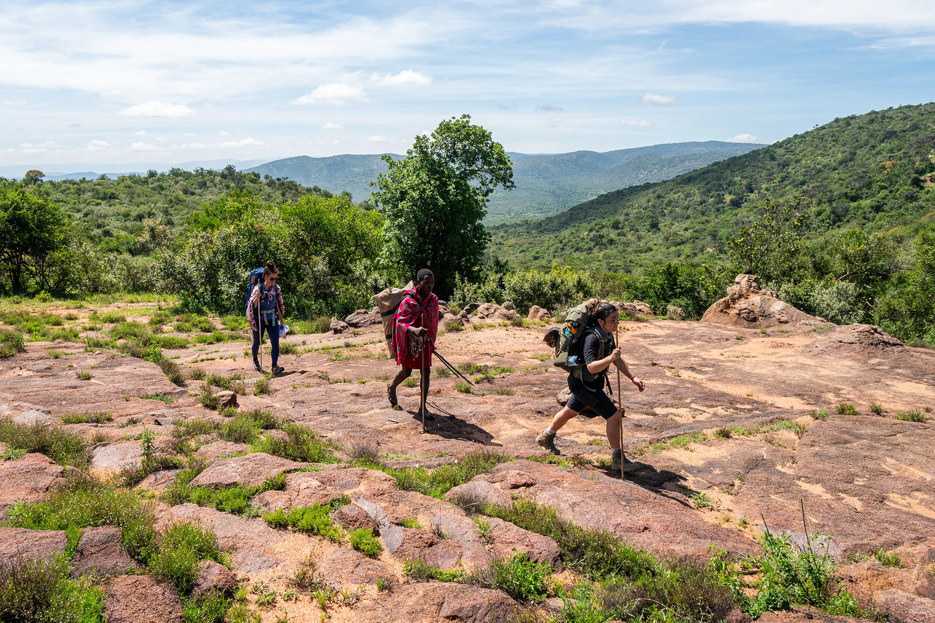 Groep wandelaars loopt over rotsig terrein