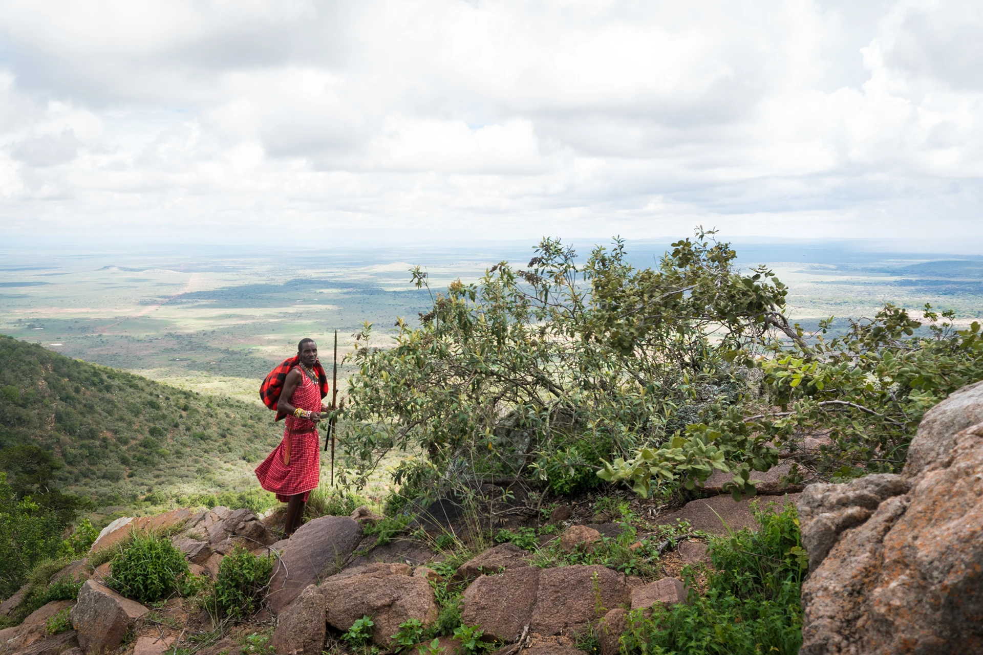 Vrouw kijkt uit over groene heuvels