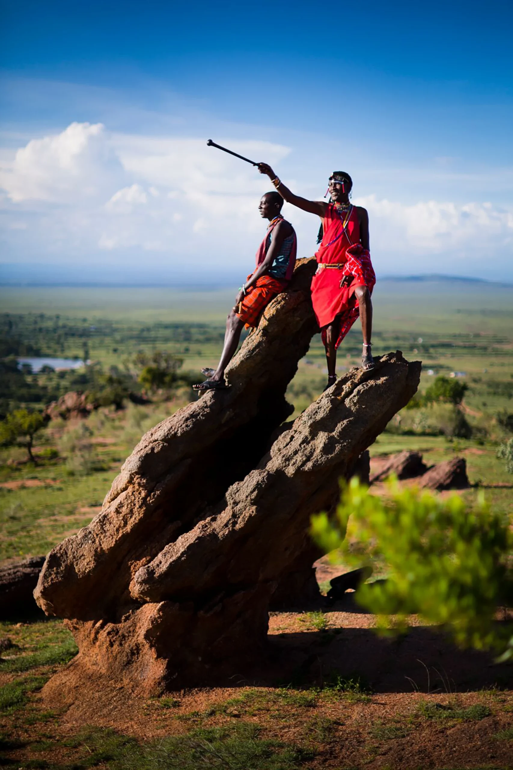 Twee mannen staan op rots met uitzicht over savanne