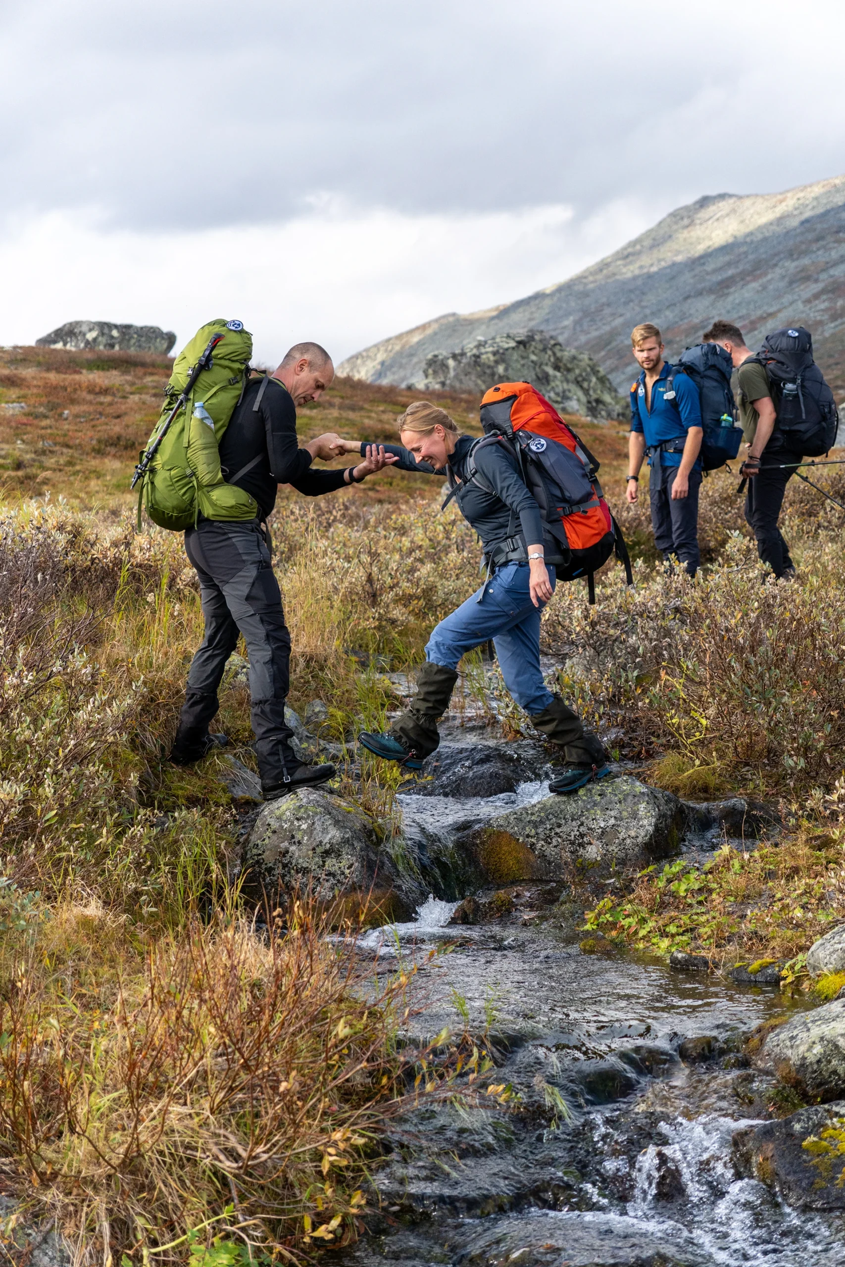 Wandelgroep die elkaar helpt op een rotsachtig pad