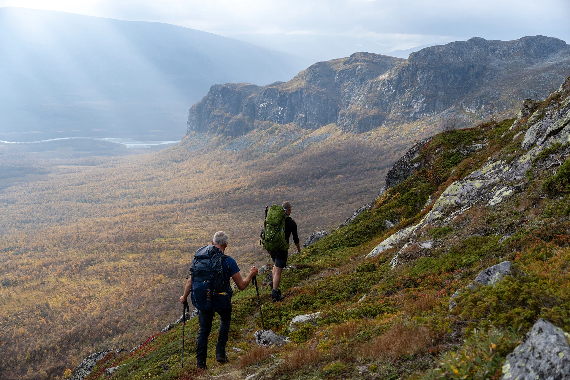 Groep hikers die door een groot bergdal lopen