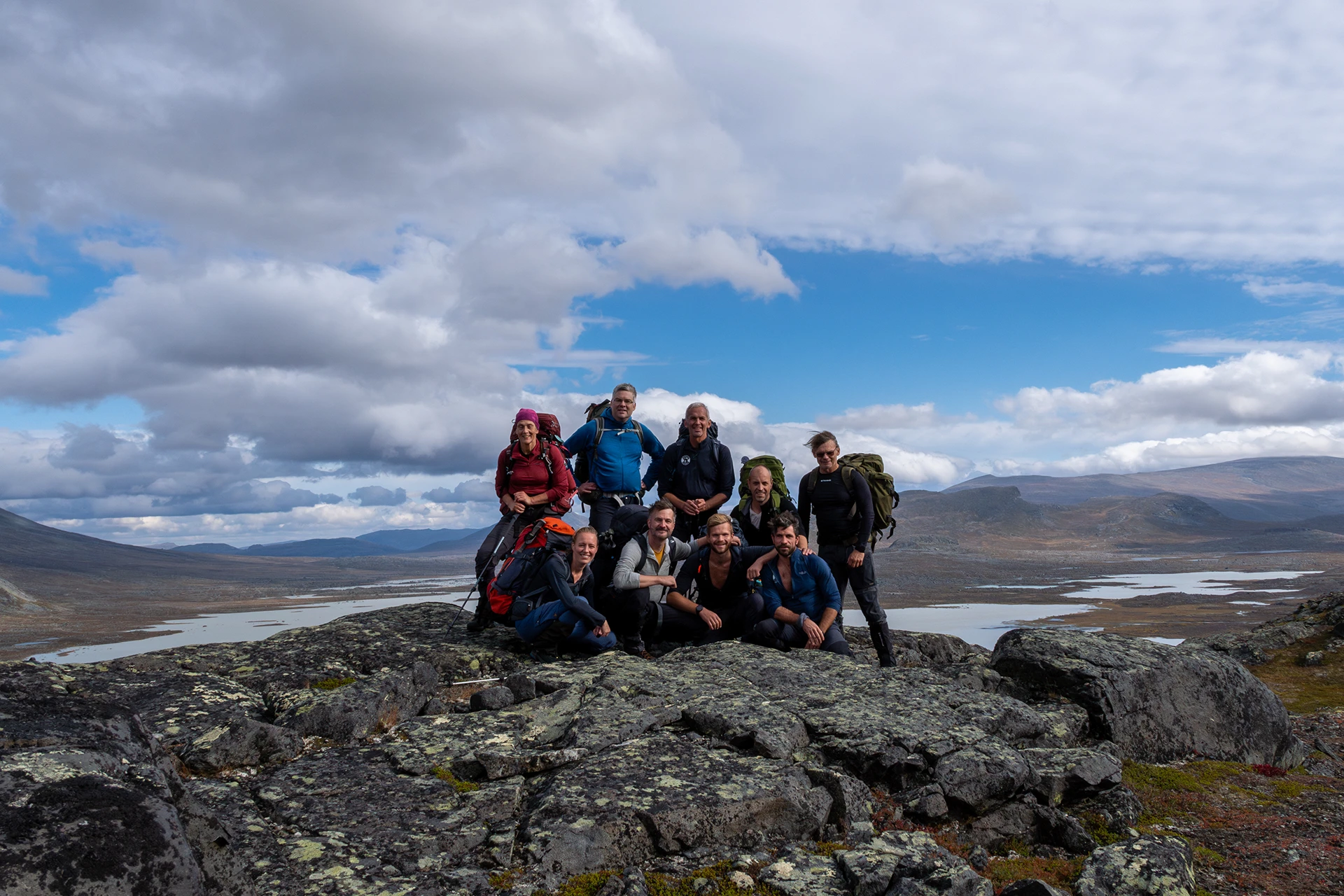 Groep wandelaars die pauzeren op een rots met uitzicht over dalen