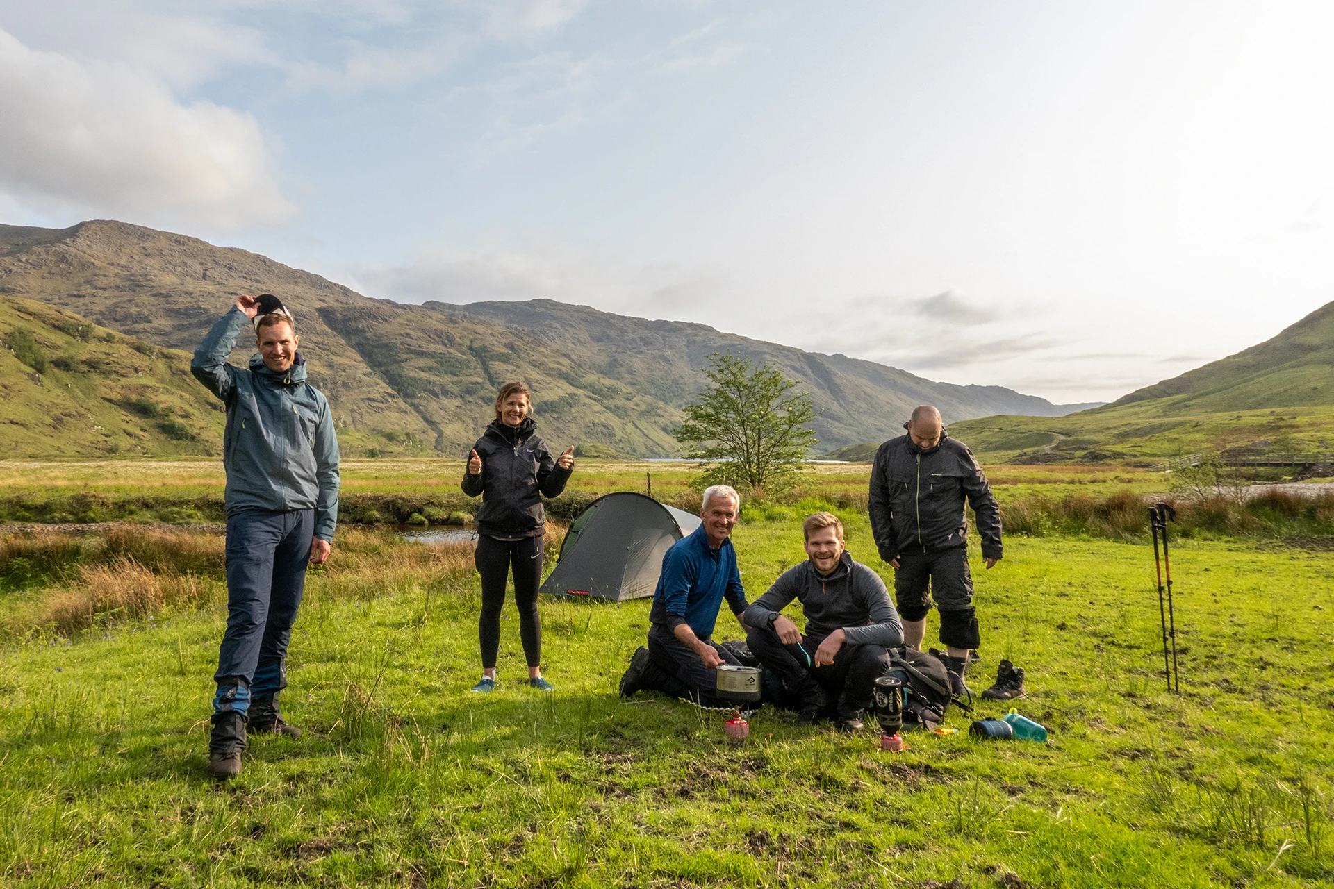 Kampeerplek waar groepje hikers pauzeert in grasland