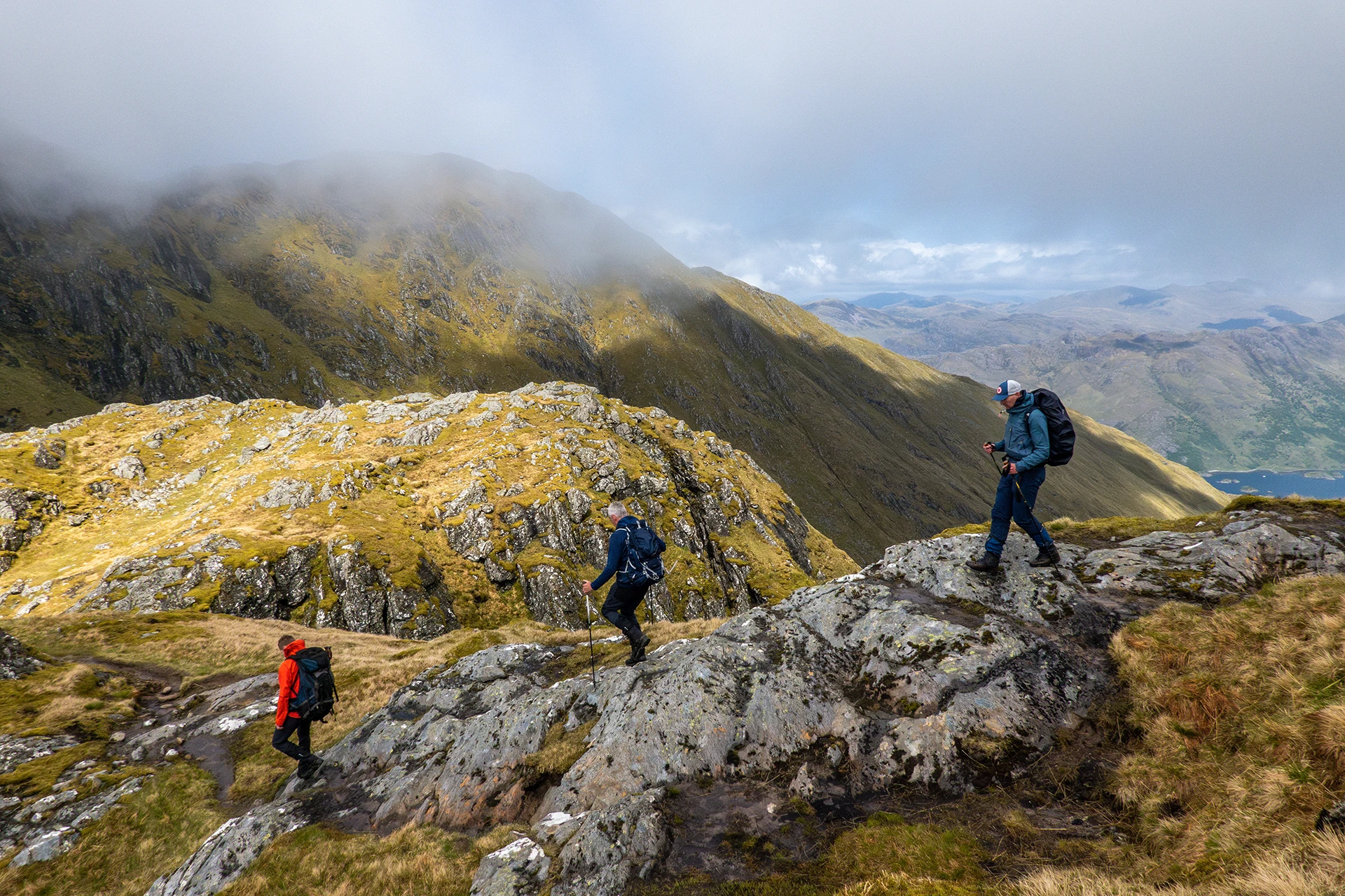 Hikers die tussen rotsen lopen met nevel langs de bergwand