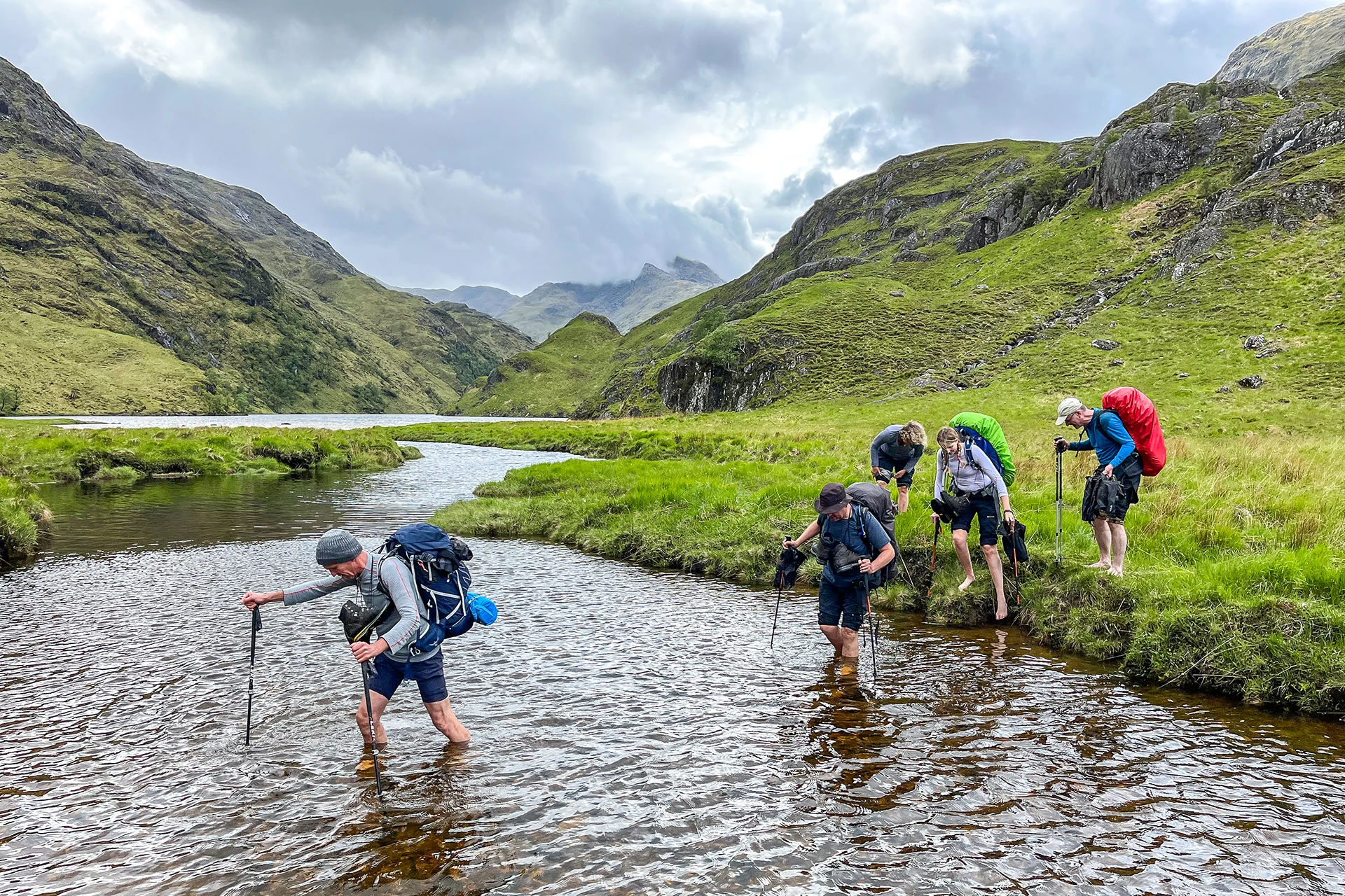 Groep wandelaars die door een ondiepe rivier loopt
