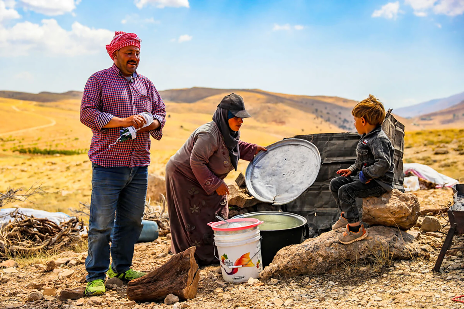 Twee mensen die eten bereiden naast een tent in een dor gebied