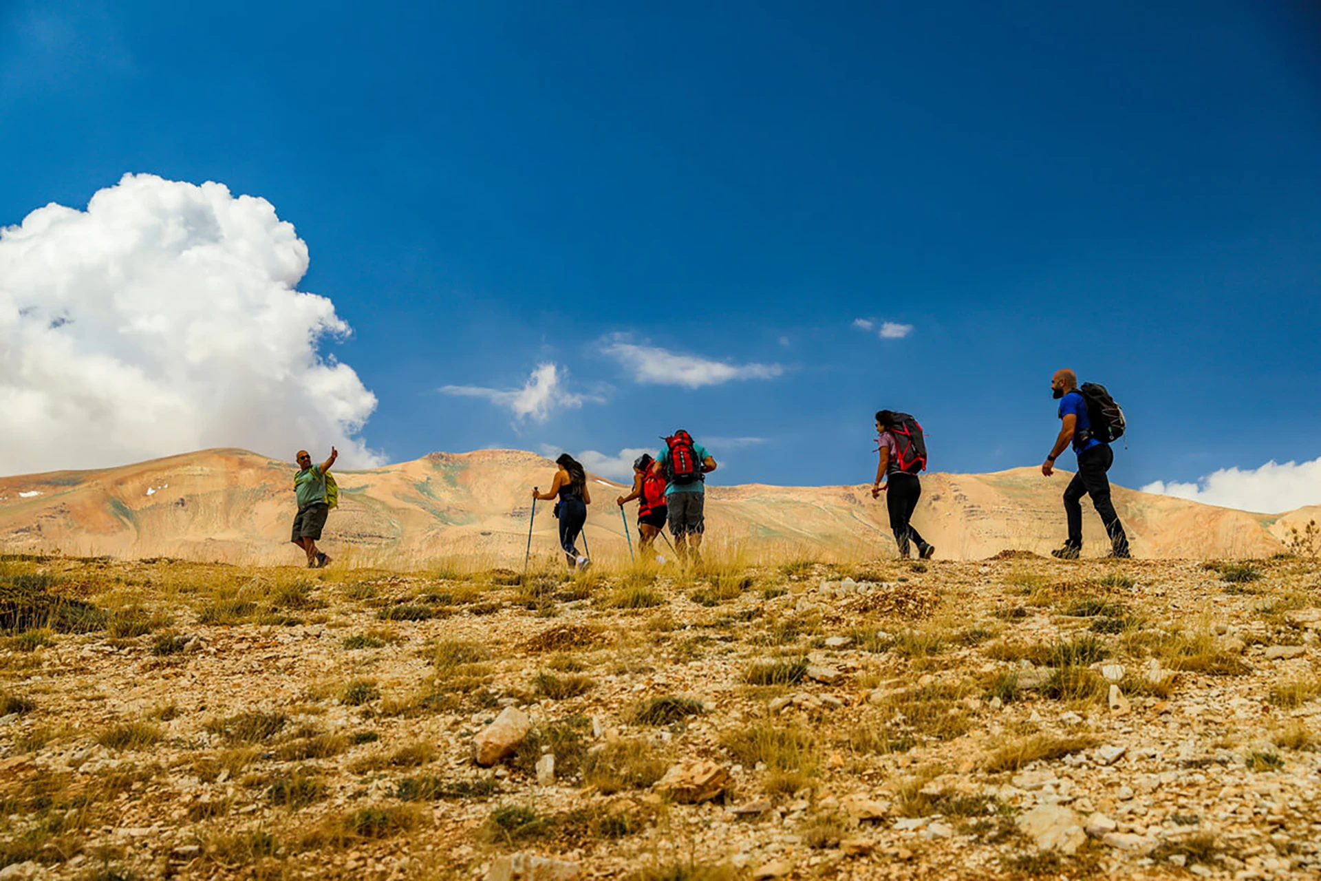 Wandelaars die door een zonnig berglandschap lopen