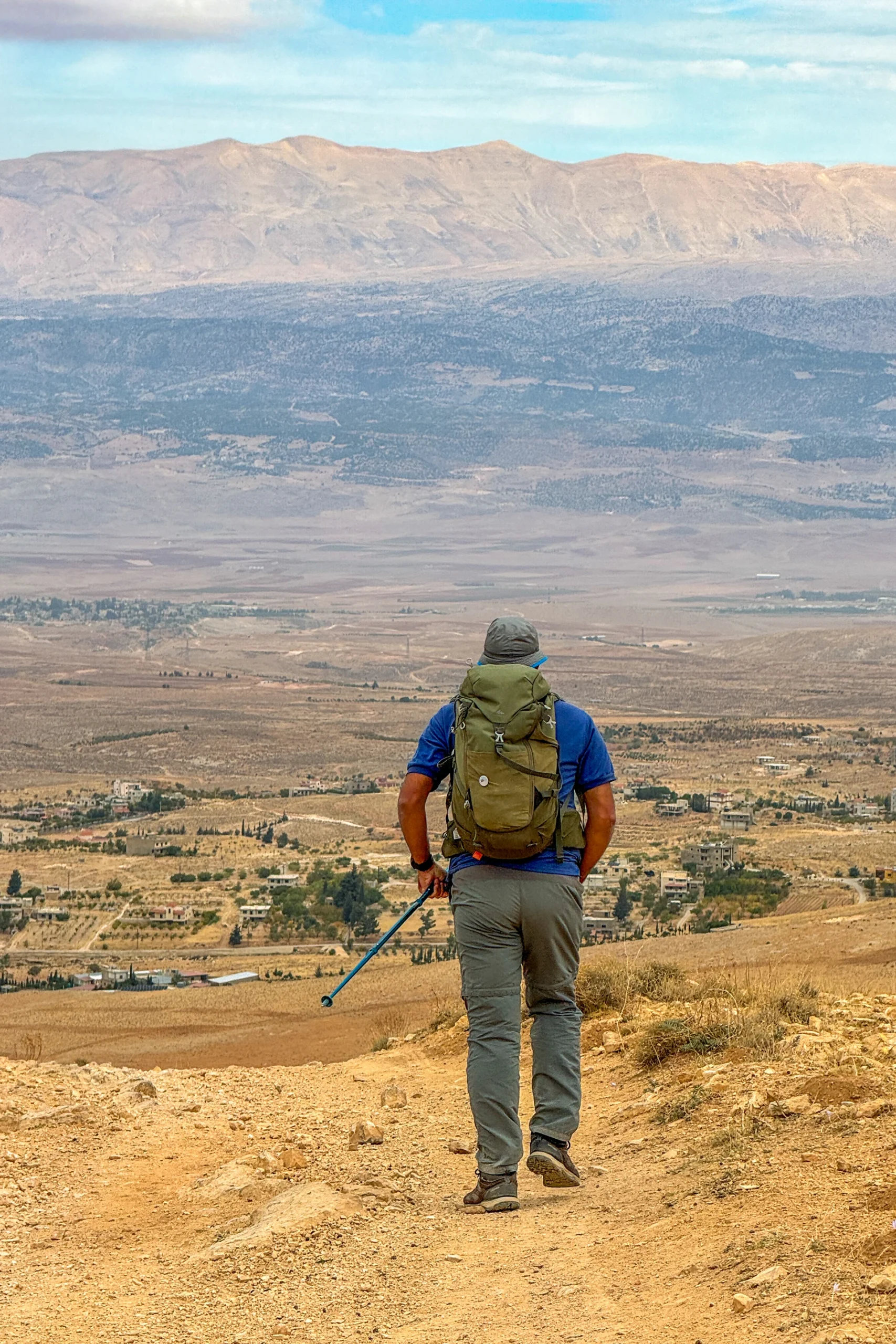 Hiker die naar een uitgestrekt woestijnachtig landschap kijkt