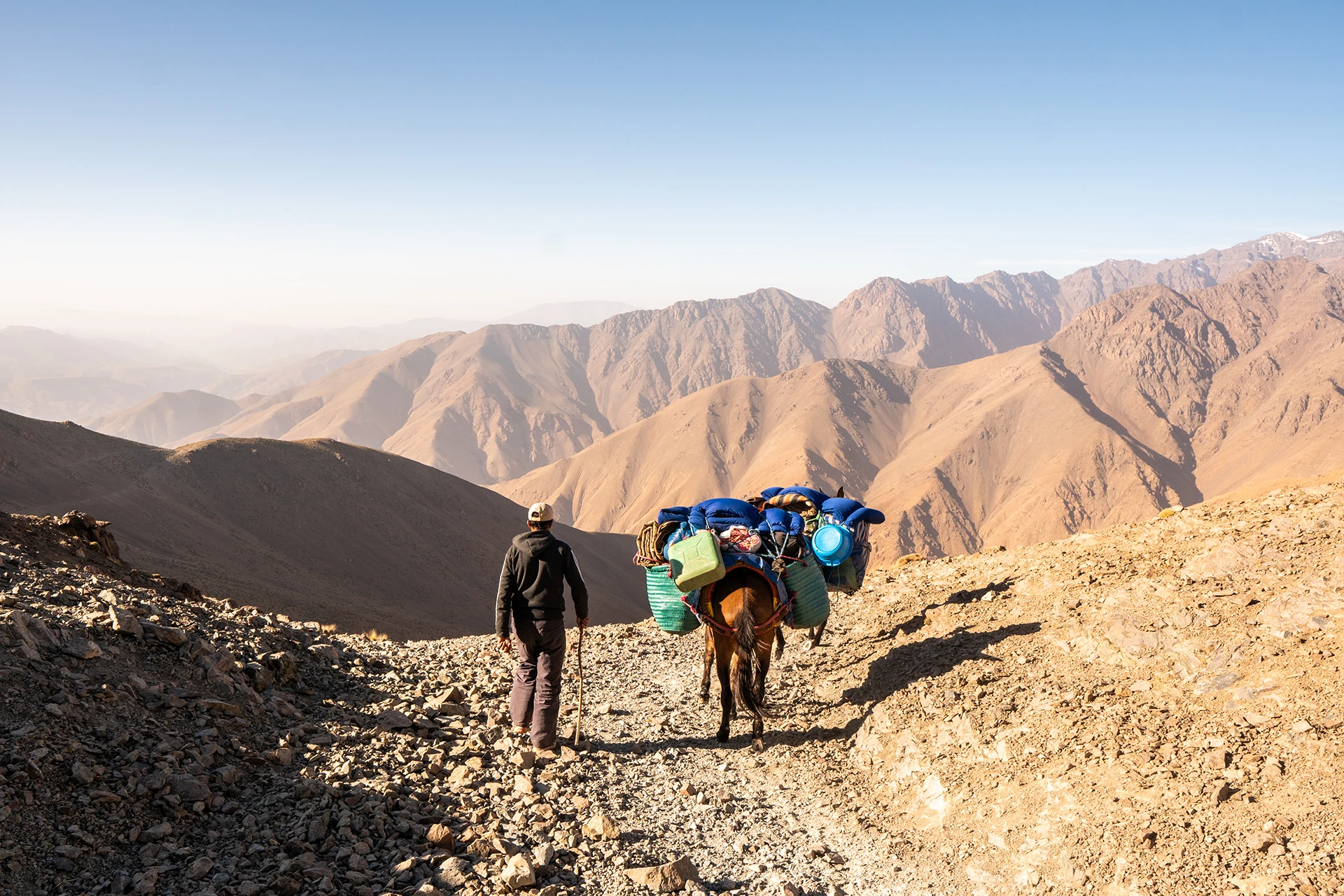 Herders met lastdieren onderweg over een droge bergpas
