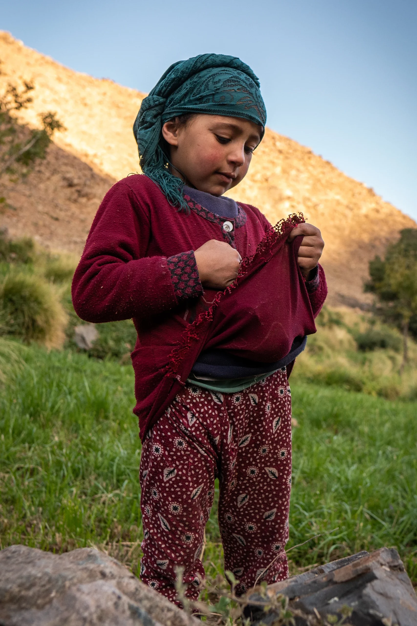 Kind dat in bergdorpje buiten staat in warm avondlicht