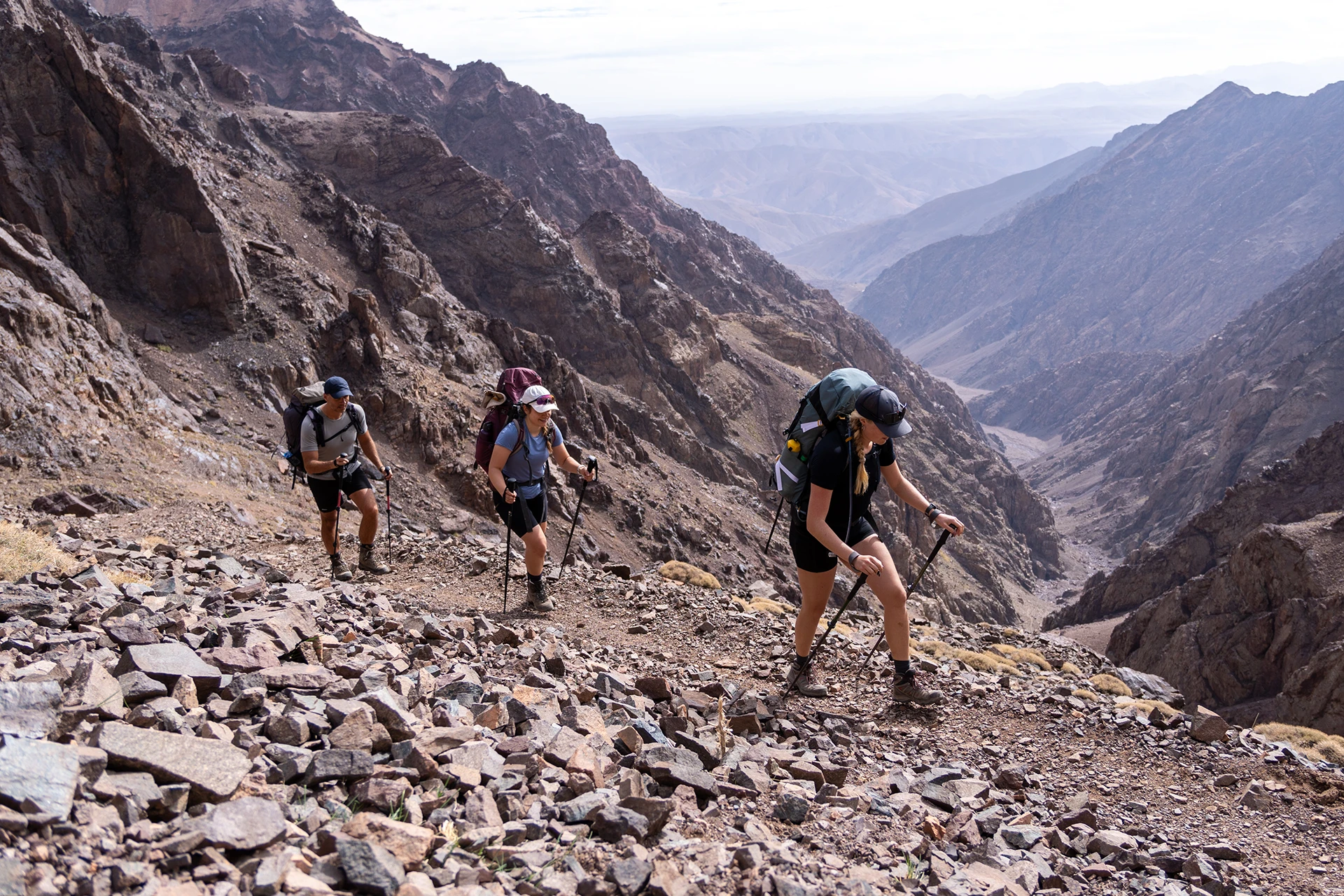 Wandelgroep die een steile rotshelling op loopt in een droog berggebied