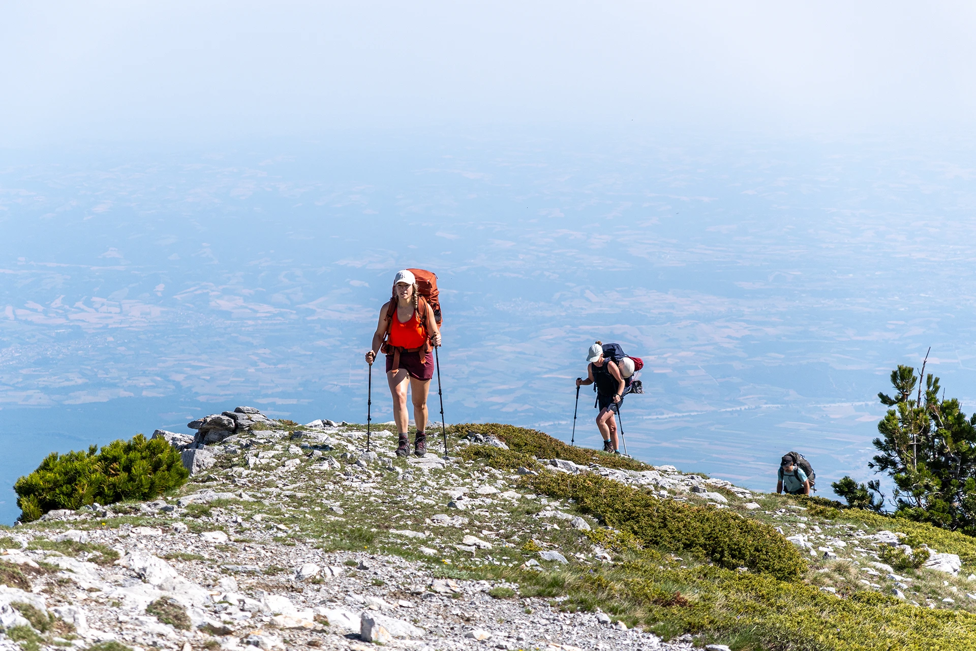 Hiker die op een berghelling staat met zeezicht in de verte