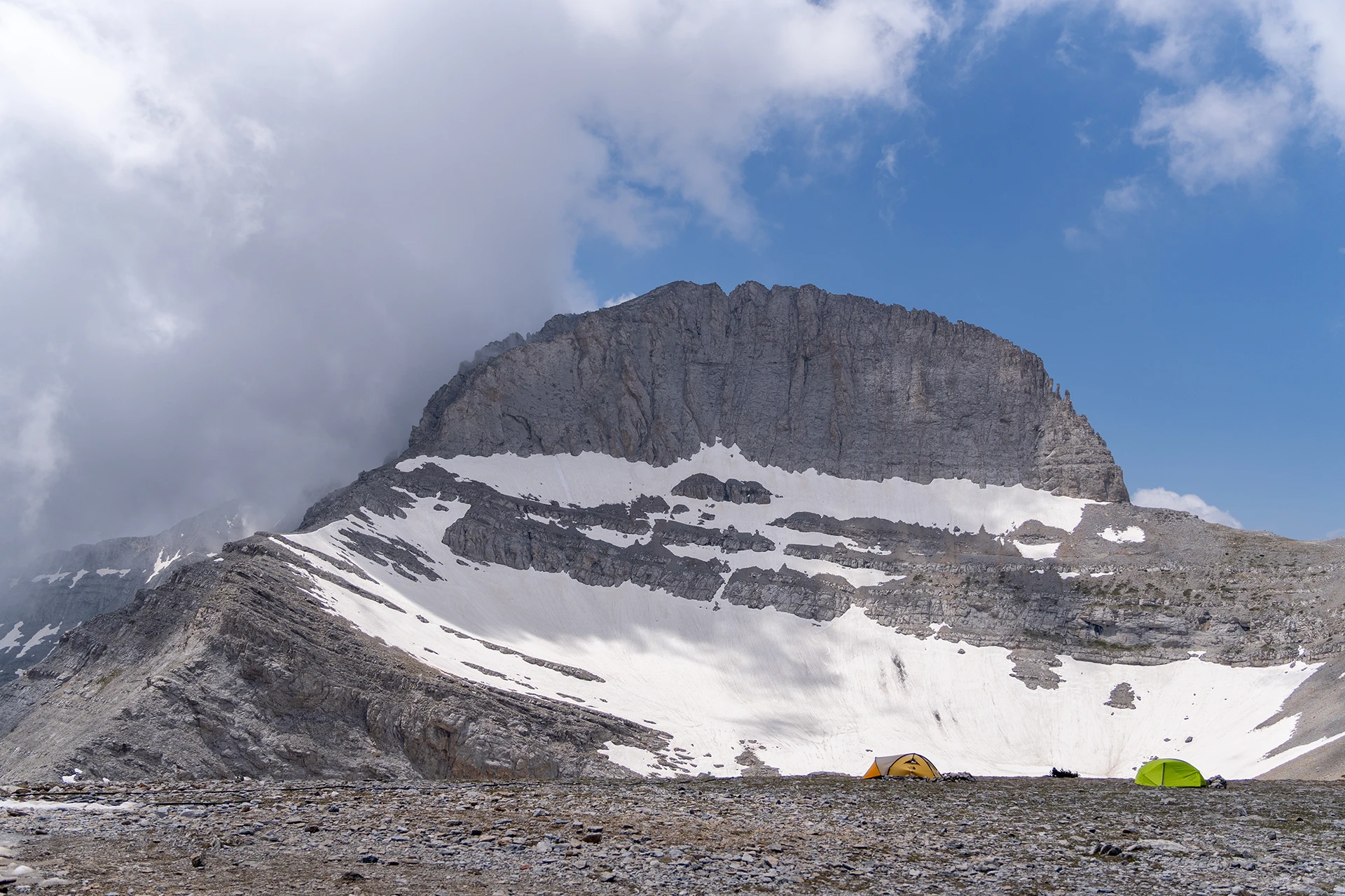 Besneeuwde top met steile wanden onder een blauwe lucht