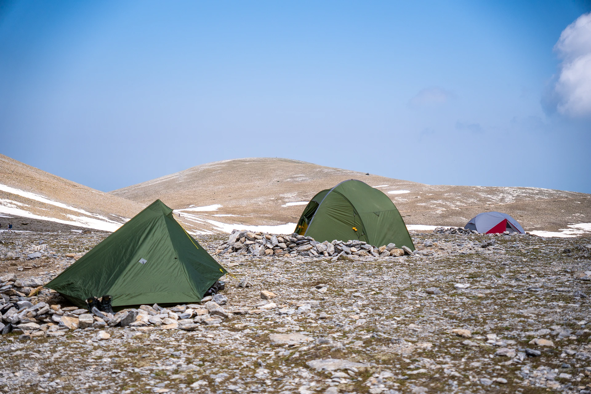 Tenten op een open bergplateau met helder weer