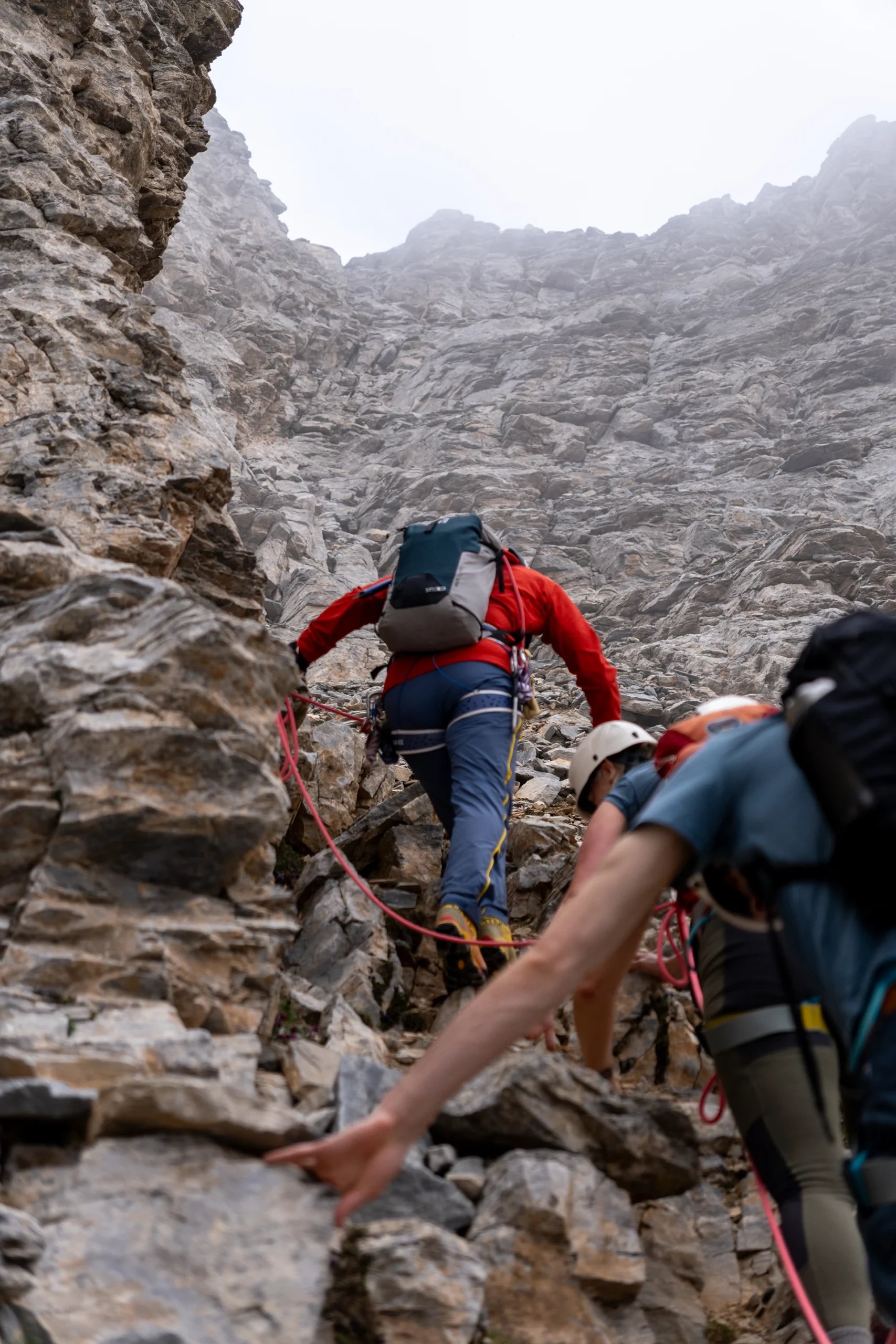 Klimmer die langs een steile rotswand omhoog gaat
