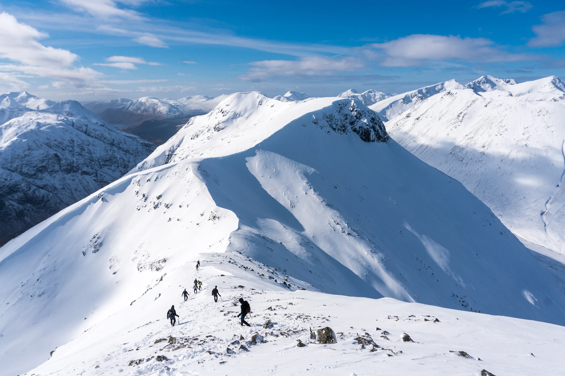 Besneeuwde bergkam met diepe dalen onder helder licht