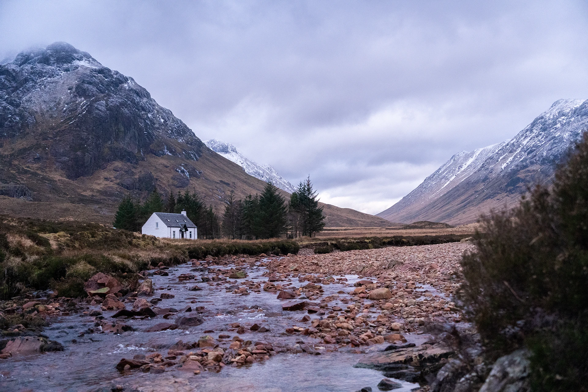 Berglandschap met een kleine witte hut langs een rivier