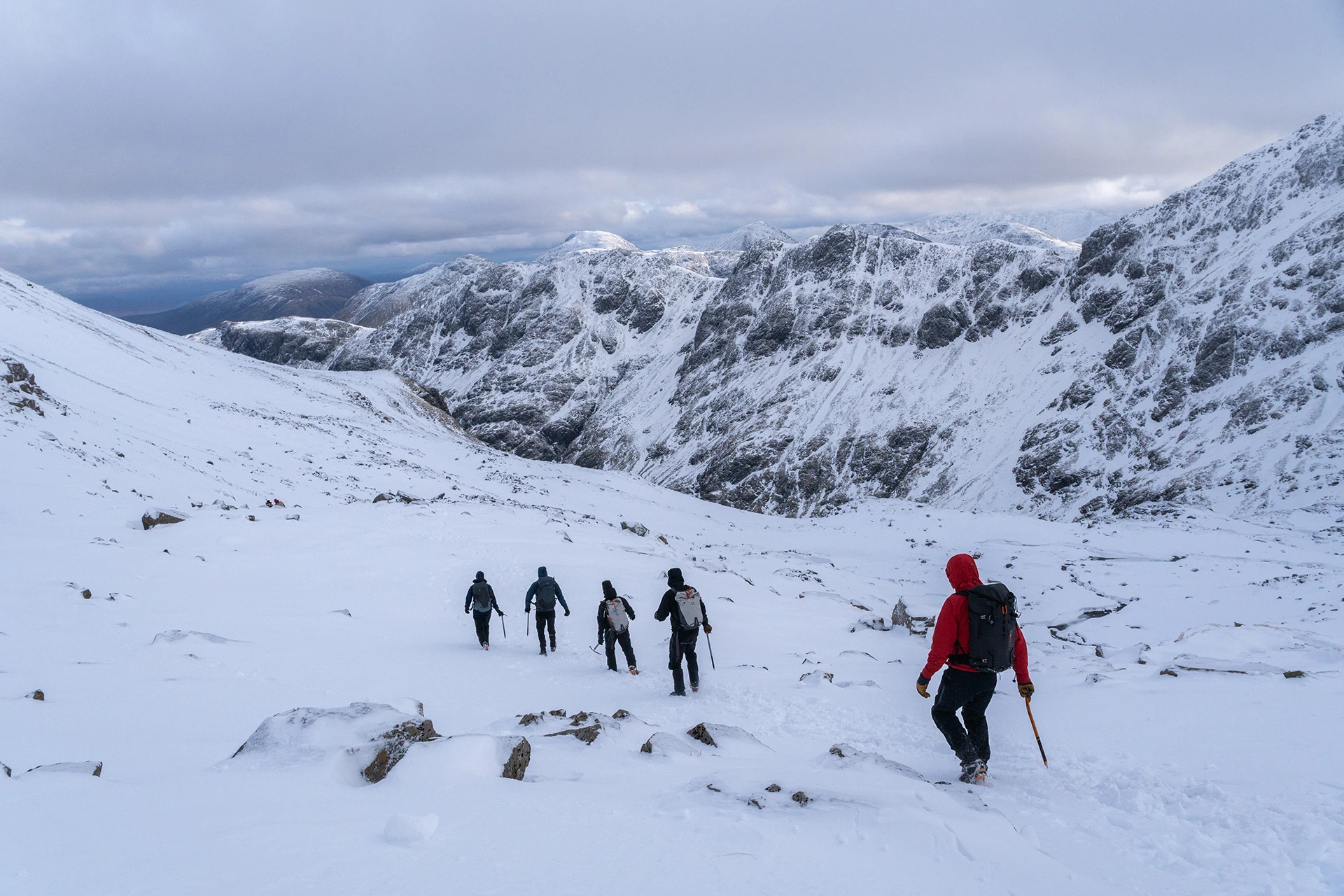 Wandelaars die in groep een brede sneeuwvlakte oversteken