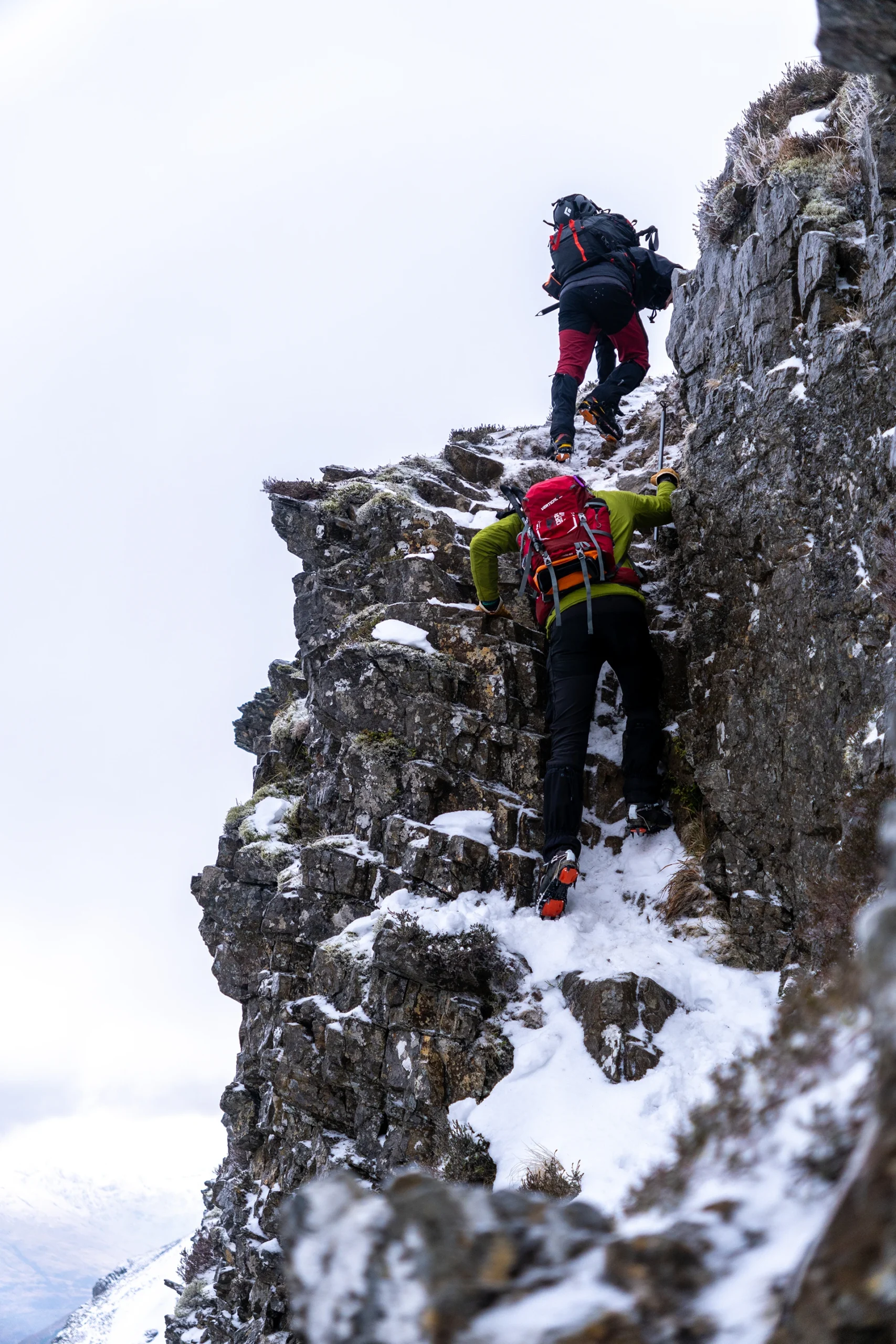 Klimmer die tegen een steile rotswand omhoog klimt