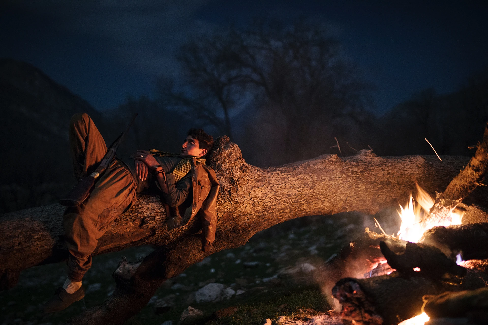 Mensen die rond een kampvuur zitten in de avond