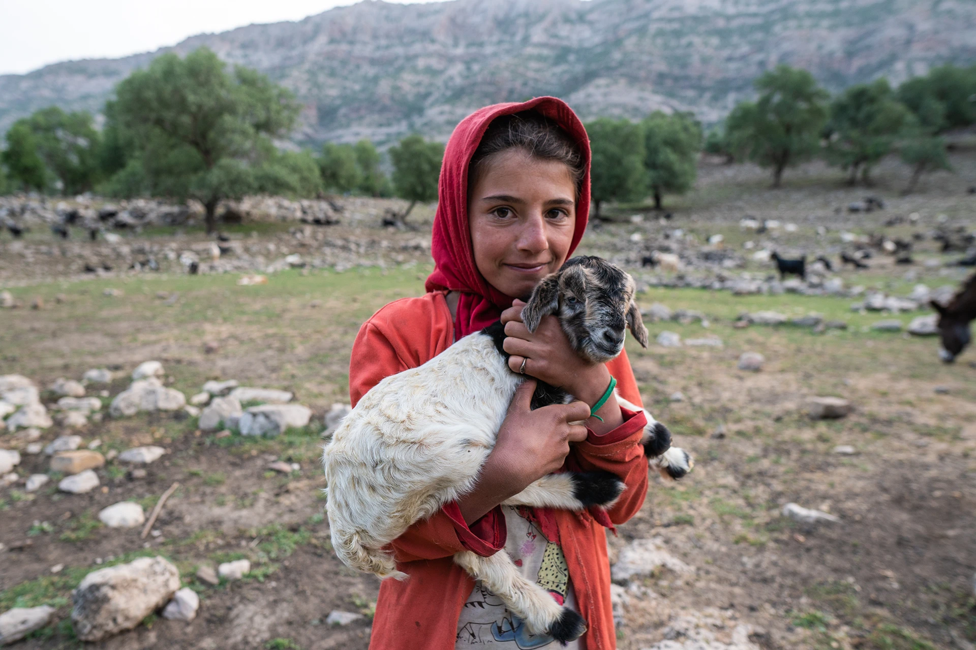 Kind dat een jong geitje vasthoudt in een bergdorp