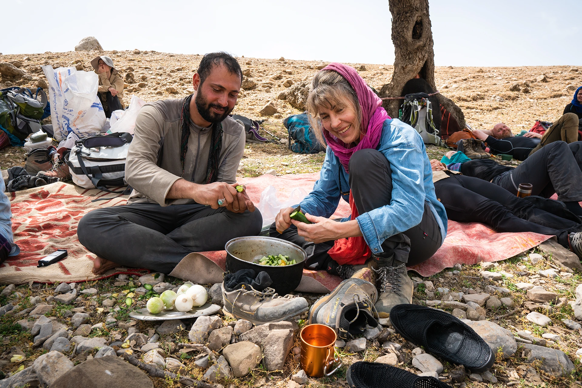 Wandelgroep die door een brede vallei met rotswanden trekt