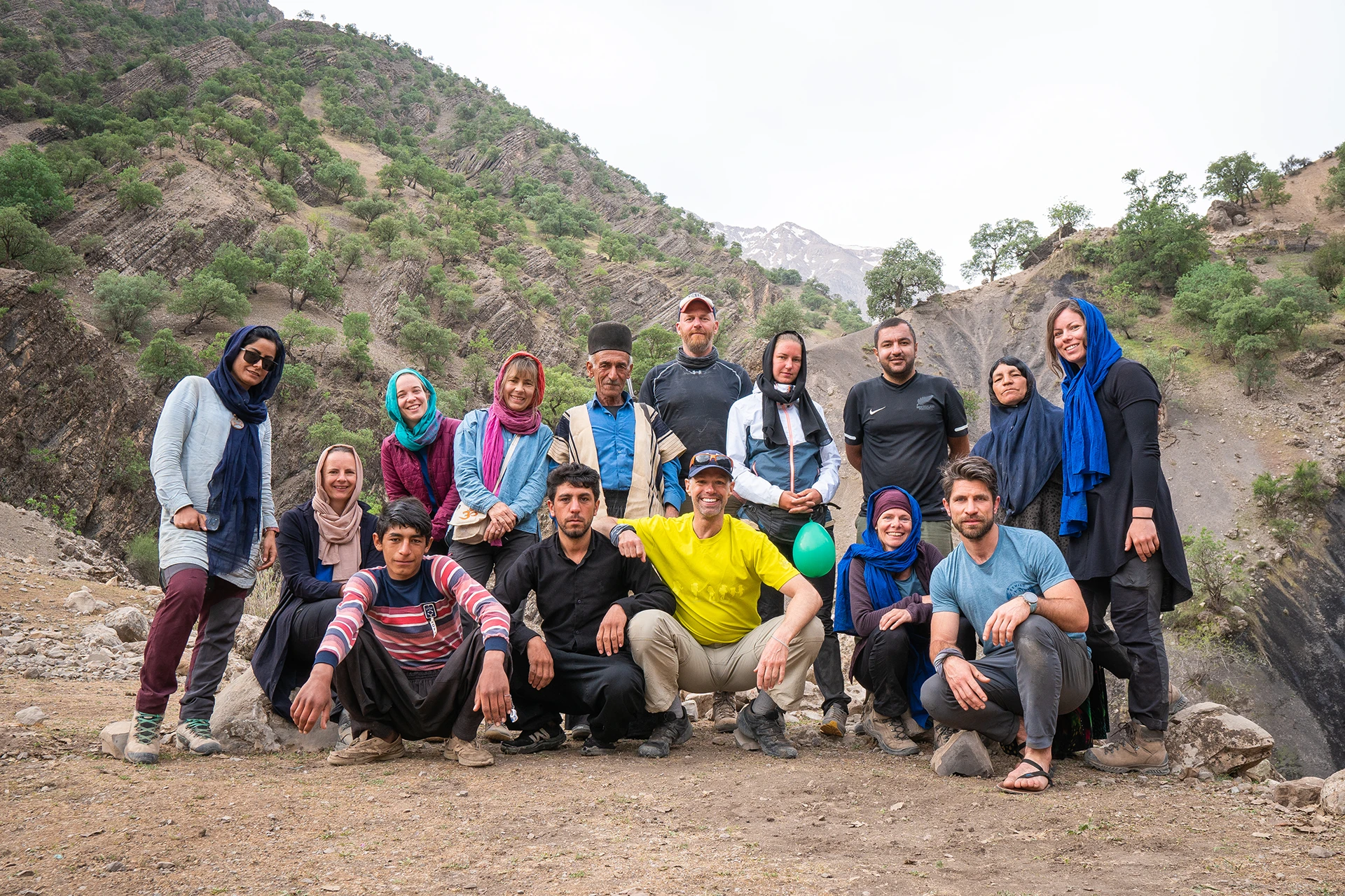 Groep reizigers die samen poseert in een bergachtige vallei