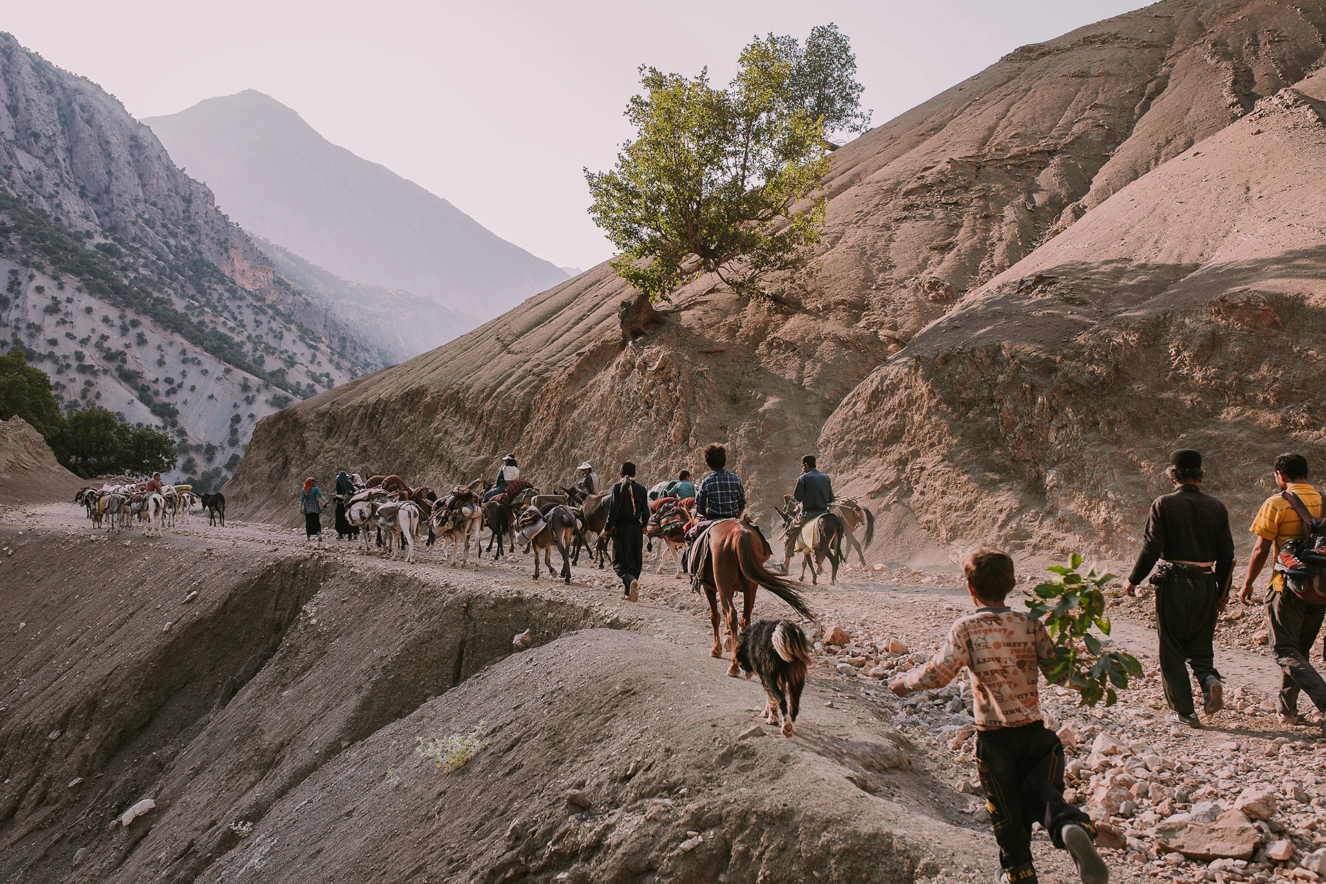 Groep wandelaars die langs een rotswand door een droge kloof loopt
