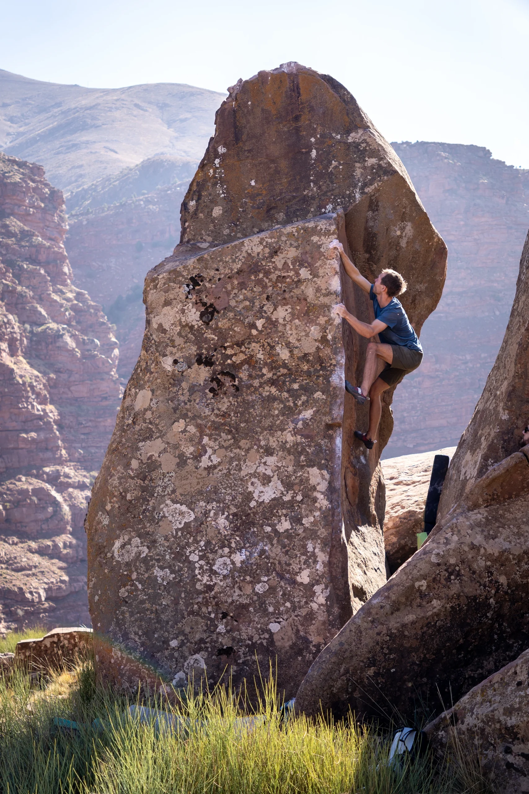 Klimmer die tussen twee grote rotsblokken omhoog gaat