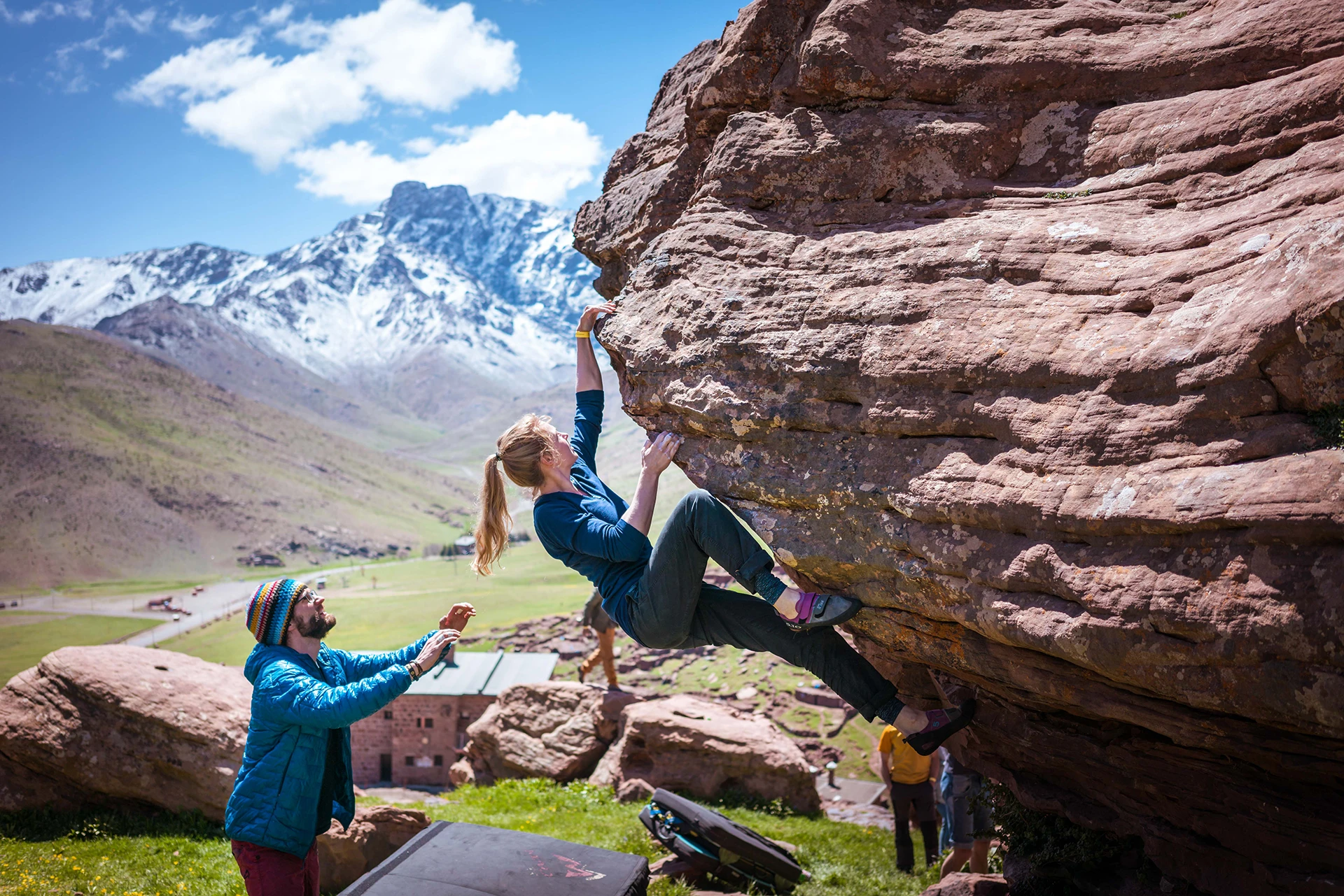 Klimmer die tegen een rotsblok traint met matten op de grond