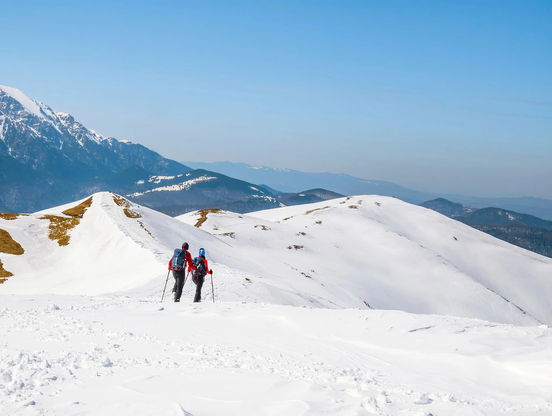 Wandelaar in een besneeuwd landschap met blauw uitzicht