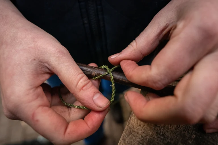 Handen die een knoop leggen met dun koord