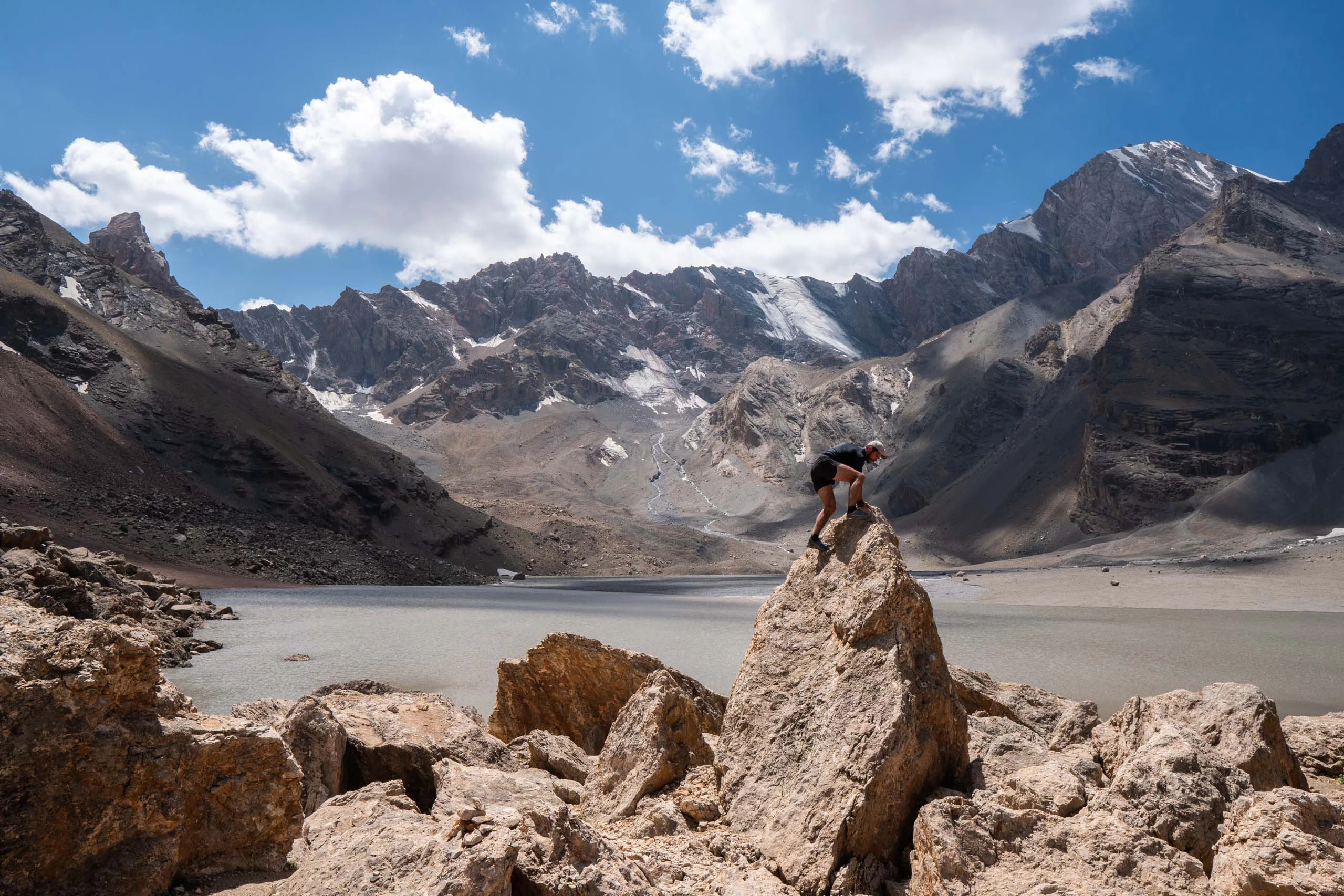 Hiker die door een rotsachtig berggebied loopt bij blauwe lucht