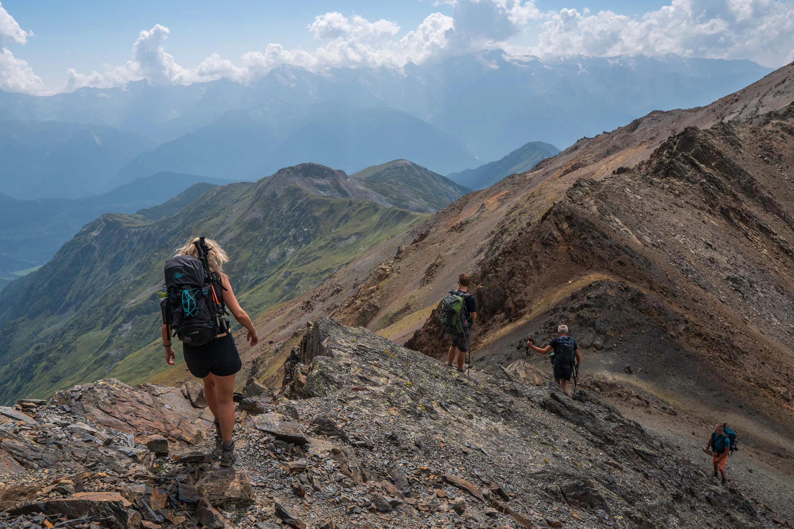 Wandelaar die door een brede vallei met bergen wandelt