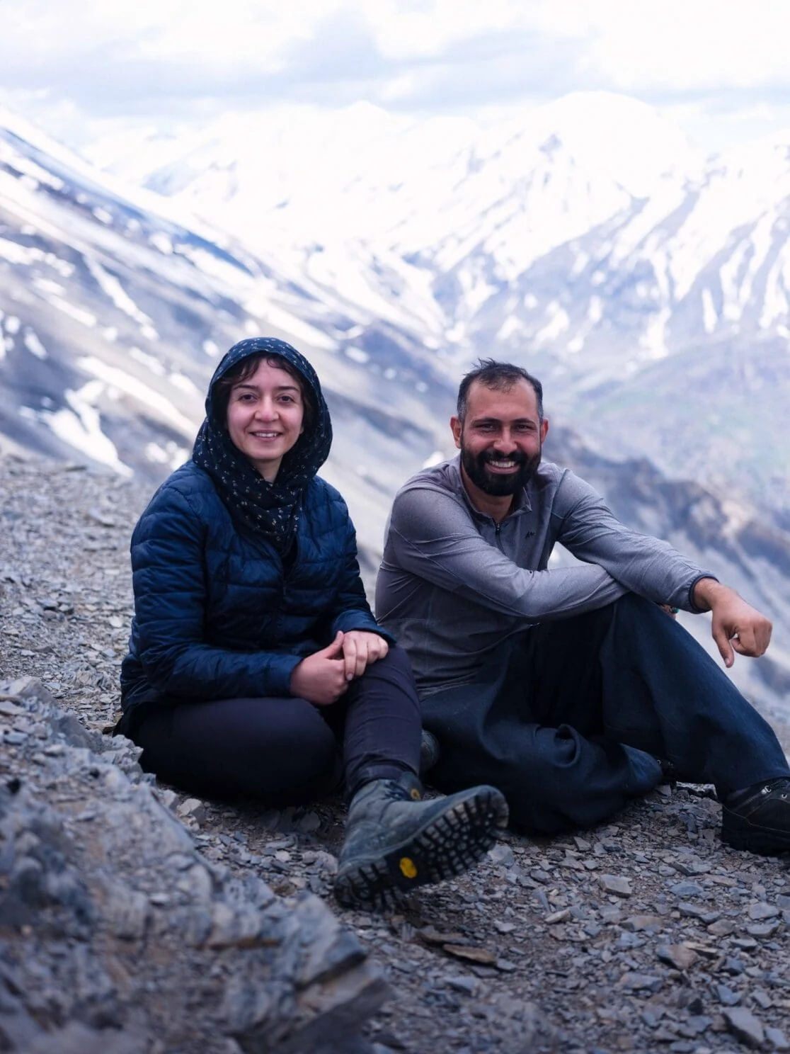 Een man en een vrouw zitten op een besneeuwde berg