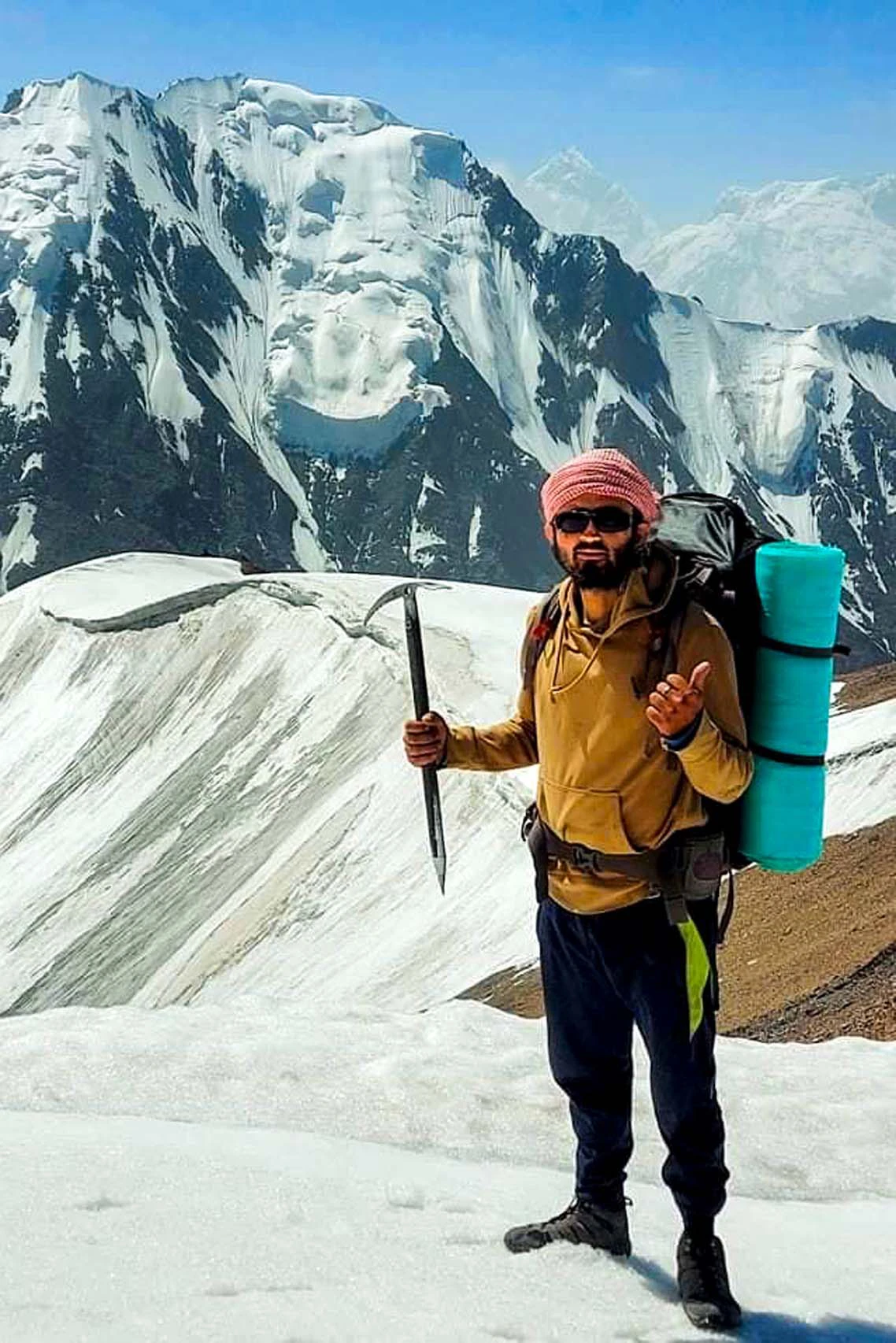 Wandelaar met rugzak in besneeuwd hooggebergte