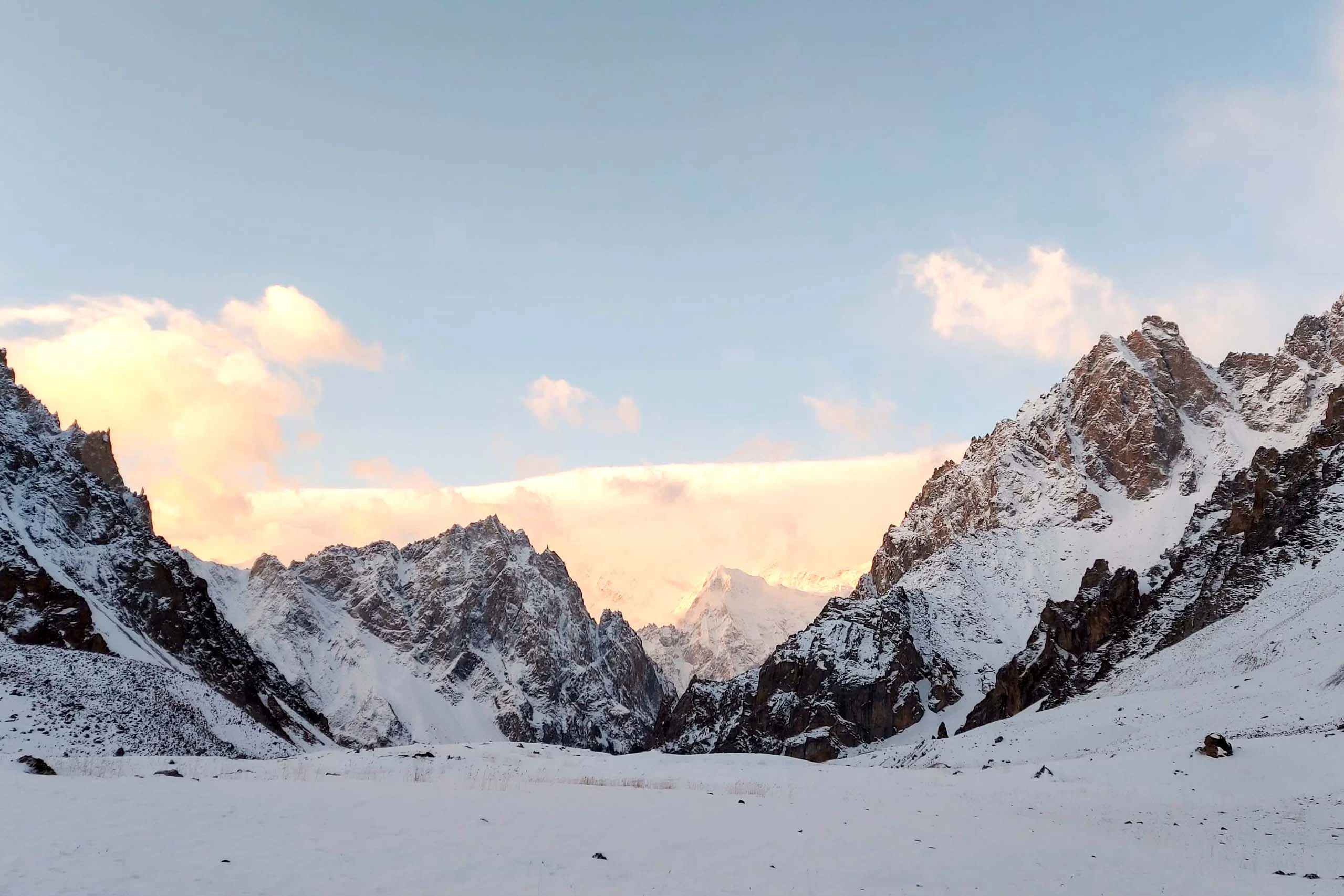 Besneeuwd berglandschap bij zonsopkomst met zachte kleuren