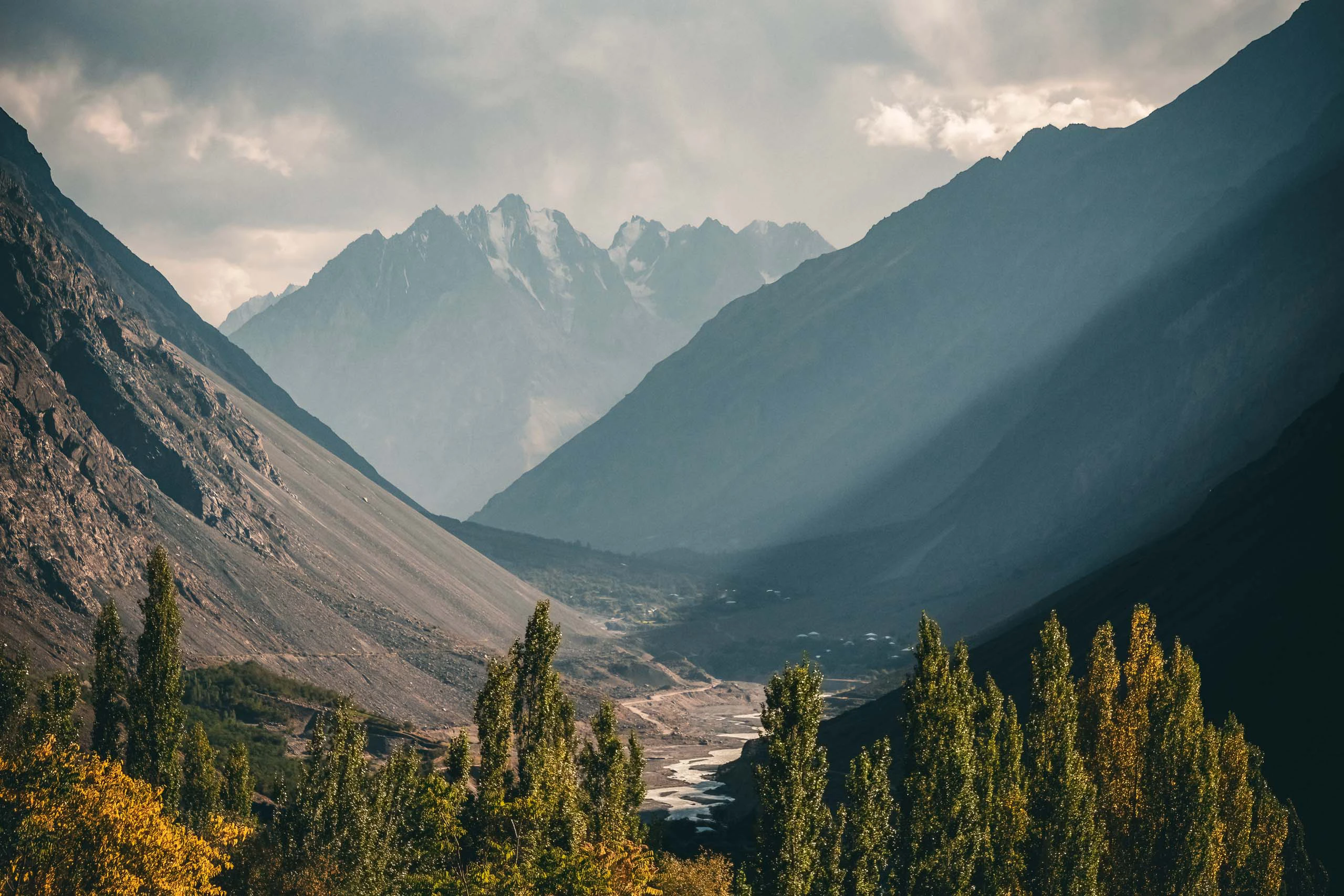 Berglandschap met gelaagde bergkammen en zonnestralen door de nevel