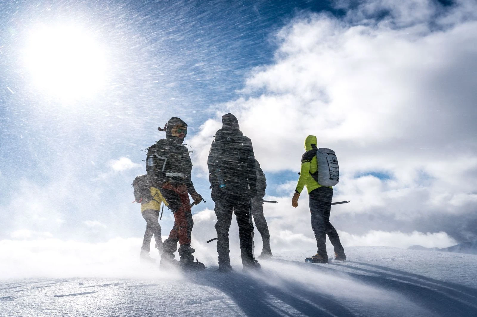 Klimmers die in harde sneeuw en wind staan